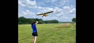 A spectator photographs a small plane making a low flyby