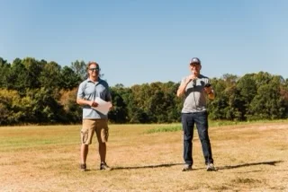 Two organizers on the grass field at a fly-in